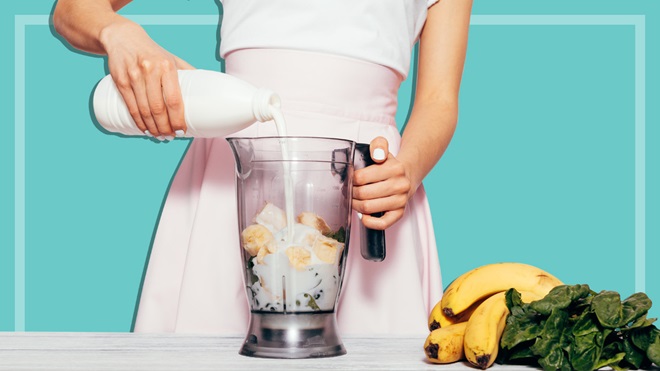 woman making a smoothie with blender
